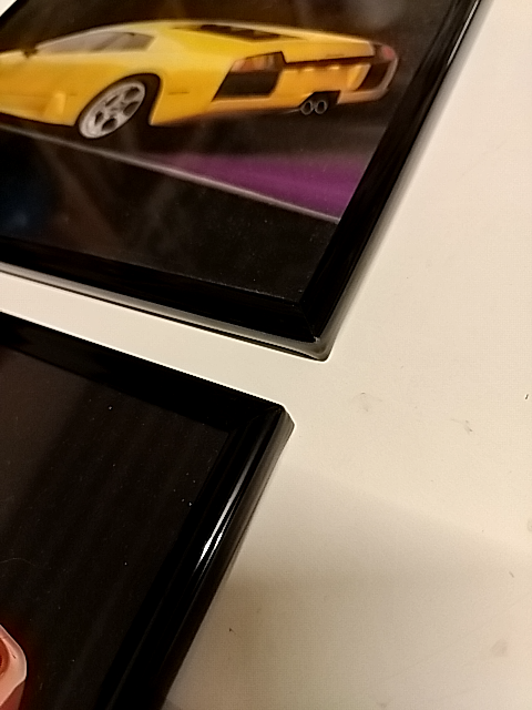 To dejligt støvede 80erbilleder i ramme: Lamborghini og Ferrari.